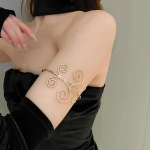 Detailansicht eines eleganten, hohlen Metall-Armreifs mit Goldwirbelmustern am Modell