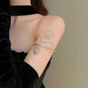 Detailansicht einer goldenen spiralförmigen Armspange am Oberarm des Models