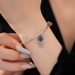 Nahaufnahme eines Hamsa-Hand-Armbands mit funkelndem Zirkon-Blick-Anhänger am Handgelenk