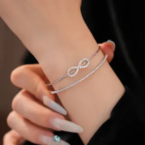 Detaillierte Nahaufnahme eines silberfarbenen Infinity-Armreifs und Pave-Armband-Sets