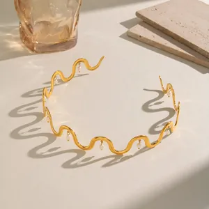 Detailansicht eines goldenen gewellten Edelstahl-Chokers mit Perlenanhängern