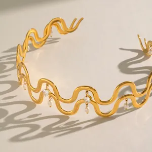 Detailansicht eines wellenförmigen Halsreifs aus Edelstahl mit Perlen und Zirkon.