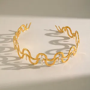 Elegantes Detail eines gewellten goldenen Chokers aus Edelstahl mit Perlen und Kristallen