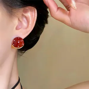 Detailopname van retro rode polkadot oorbellen in paddenstoelstijl met emaille afwerking