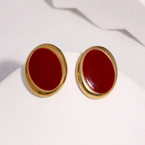 Detailaufnahme ovaler Retro-Ohrstecker mit tiefroter Emaille und goldenem Finish