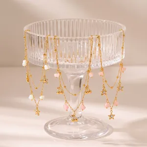 Detailansicht goldener Edelstahlschichtenketten mit schönen Stern- und Kirsch-Anhängern