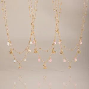 Detailansicht goldener Edelstahlketten mit Stern-, Kirsch- und Blumenzirkonia-Anhängern.