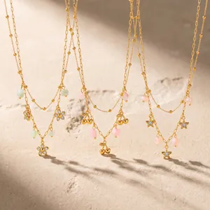 Detailansicht von drei Goldhalsketten mit Blumen-, Kirsch- und Sternanhängern
