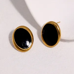 Nahaufnahme minimalistischer Retro-Ohrstecker in Gold mit schwarzer Emaille