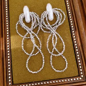 Detailansicht von edlen mehrlagigen Perlen-Tassel-Ohrringen mit weißen Barockperlen