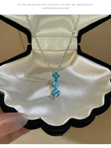 Vue détaillée d'un collier en argent avec trois pendentifs fleurs en zircon bleu