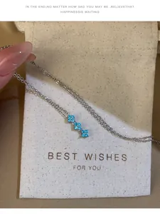 Gros plan détaillé du pendentif fleur en zircon bleu sur une chaîne en argent
