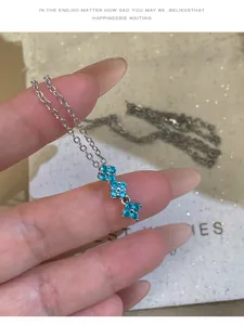 Gros plan d'un collier pendentif fleur avec zircons bleus sur une chaîne en argent
