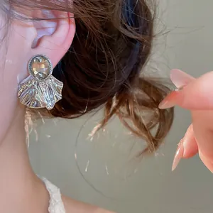 Détail chic de boucles d'oreilles en éventail avec cristal fumé et plis argentés.