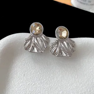 Vue détaillée de boucles d'oreilles argentées plissées avec pierres champagne