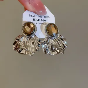 Vue détaillée de boucles d'oreilles argentées en forme d'éventail plissé avec strass