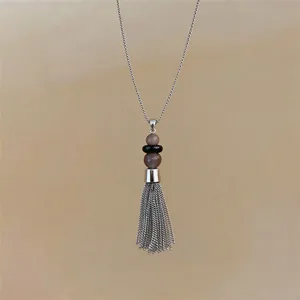 Detailweergave van een roestvrijstalen ketting met kwastje, kralen en kettingen.