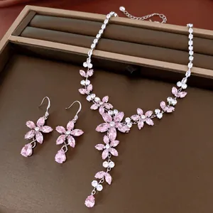 Detail van roze bloemen sieradenset inclusief ketting en oorbellen op een display tray