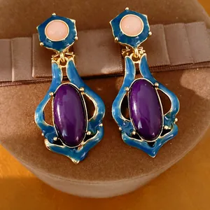 Detaillierte Makroansicht von Vintage-Ohrringen mit blauem Email und goldenem Metallrand.