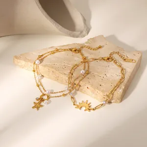 Detailed view of gold stainless steel bracelets with starfish, sun charms, and pearls