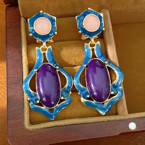 Detaillierte Makroansicht von Vintage-Ohrringen mit blauer Emaille und violetten Steinen