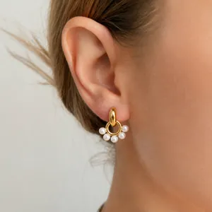 Detailed view of elegant gold stainless steel earrings featuring delicate resin pearls.