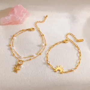 Close-up detail of gold-plated stainless steel starfish and pearl charm bracelets