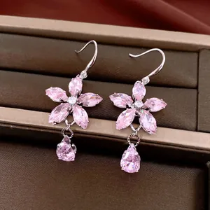 Detailweergave van roze zirkoon bloemenoorbellen met elegante kristallen druppelhangers