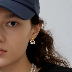 Detail shot of gold-plated stainless steel hoop earrings with five small resin pearls