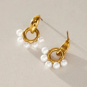 Macro detail of gold stainless steel door-handle earrings featuring elegant resin pearls.