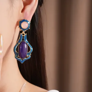Detailansicht eleganter Vintage-Emaille-Ohrringe mit lila und rosa Harzsteinen im Retro-Stil.