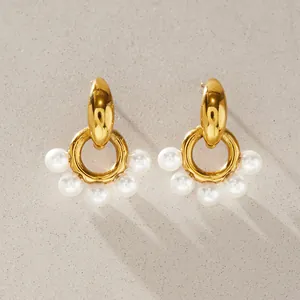 Detailed view of gold stainless steel hoop earrings featuring white resin pearls.
