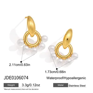 Detailed view of gold stainless steel hoop earrings with elegant white resin pearls