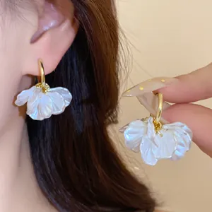 Détail des boucles d'oreilles créoles plaquées or 14 carats avec pétales de perles