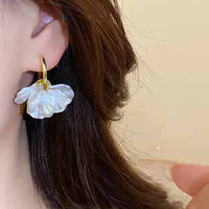 Photo macro d'une boucle d'oreille plaquée or 14k avec d'élégants pétales de perles.