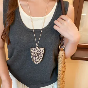 Detailopname van een vintage brilhouder ketting met luipaardprint gedragen door model