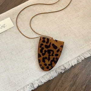 Detailopname van vintage luipaardprint brilclip halsketting op stoffen achtergrond