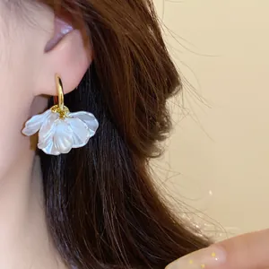Détail d'une boucle d'oreille en plaqué or 14k avec pendentif pétale de perle blanche