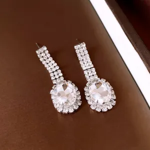 Close-up of sparkling oval rhinestone drop earrings in elegant silver-tone finish