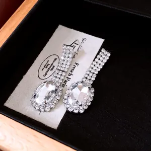 Close-up of elegant oval crystal dangle earrings with pavé rhinestone accents