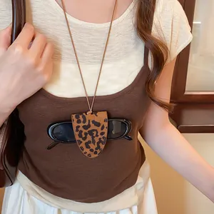 Model draagt een vintage luipaardprint zonnebrilhouder ketting boven een bruine top