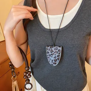 Detail van een vintage luipaard hanger ketting gebruikt als brillenhouder op een model
