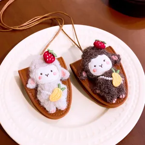 Detailed macro view of white and brown plush sheep pendants with leather cords and pouches