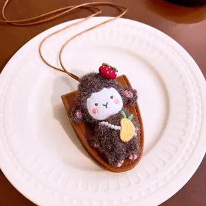Detailed view of a cute plush sheep doll pendant on a leather pouch with long cord