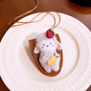 Close-up of a cute plush sheep charm featuring strawberry and carrot details on a white plate