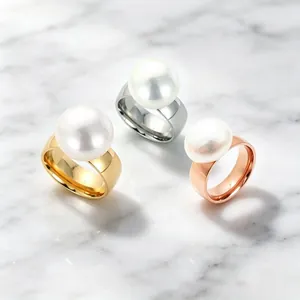 Detailansicht von drei großen Edelstahlringen mit Perlen in Gold-, Silber- und Roségold.