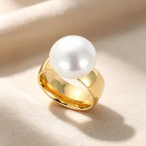 Detailaufnahme eines breiten goldenen Edelstahlrings mit einer großen weißen Perle.