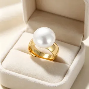 Nahaufnahme eines breiten goldenen Edelstahlrings mit einer großen weißen Perle.