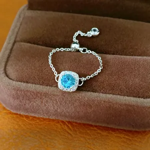 Detailansicht eines verstellbaren silberfarbenen Kettenrings mit blauem Zirkon-Mittelstück