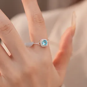 Detailaufnahme eines silberfarbenen, verstellbaren Kettenrings mit blauem quadratischem Stein